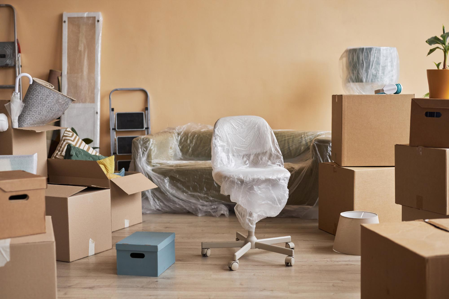 Une partie du salon d'un nouvel appartement avec des meubles enveloppés dans du cellophane